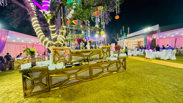 Open-air lawn decorated with hanging lanterns at dusk
